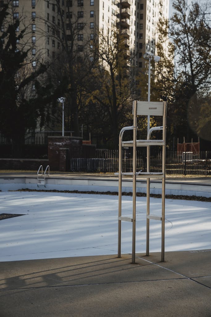 Metal chair at empty pool on sport ground